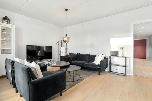 Budgetfreundliche Zimmerumgestaltung mit einem Ecksofa, schwarzer Stoff